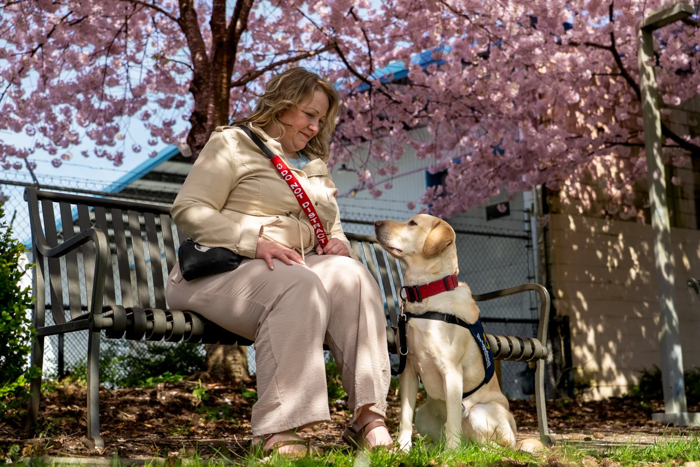 Kendall seated beneath cherry blossoms looking at Landon, who sits attentively beside her.